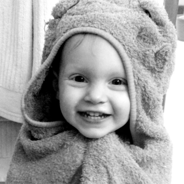 Caleb's son Jude as a toddler wrapped in a towel